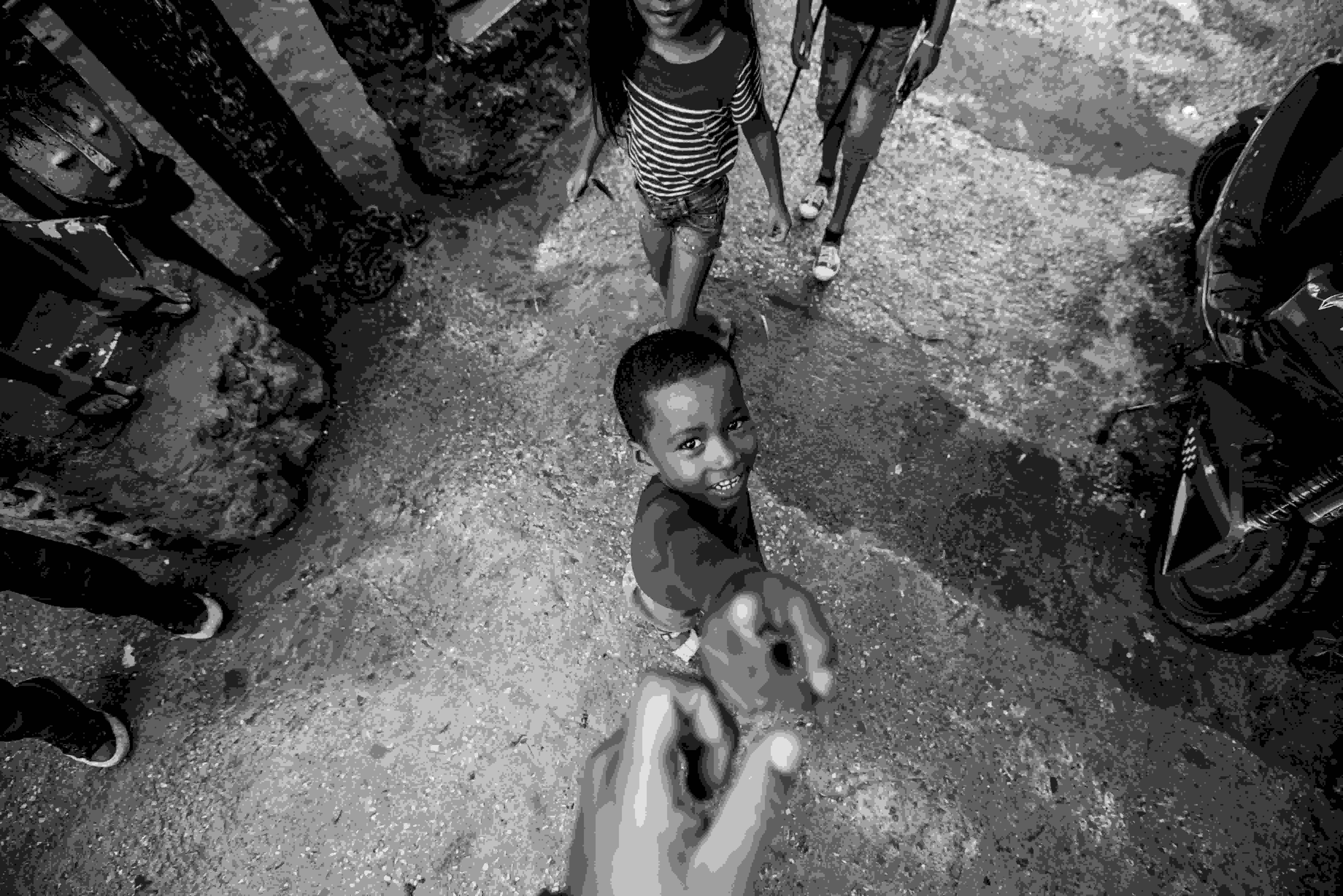 A picture of a young boy reaching up to hold someone's hand as an indication of impact created in someone's life